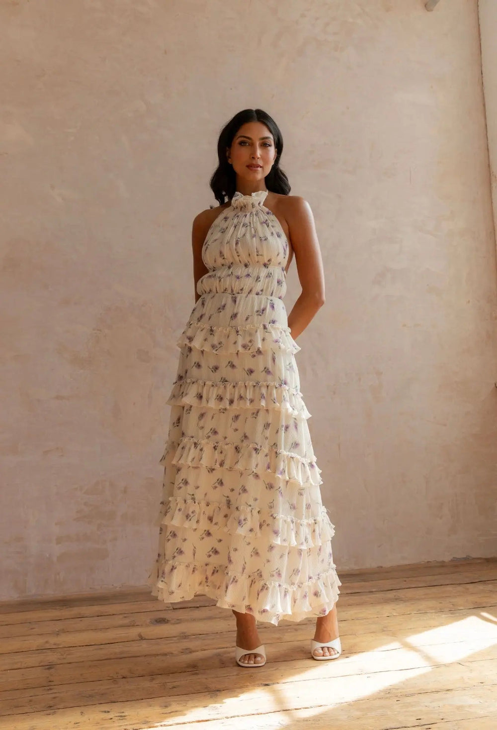 Anne Louise Boutique Ada floral dress displayed on a hanger with colorful floral patterns and flowing fabric.