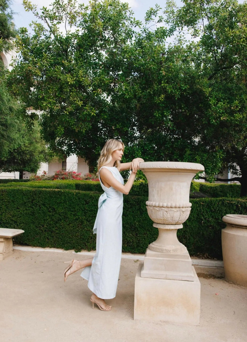 Blue bow maxi dress by Anne Louise Boutique featuring a flowing fabric, elegant bow detail at the shoulder, and a floor-length design.