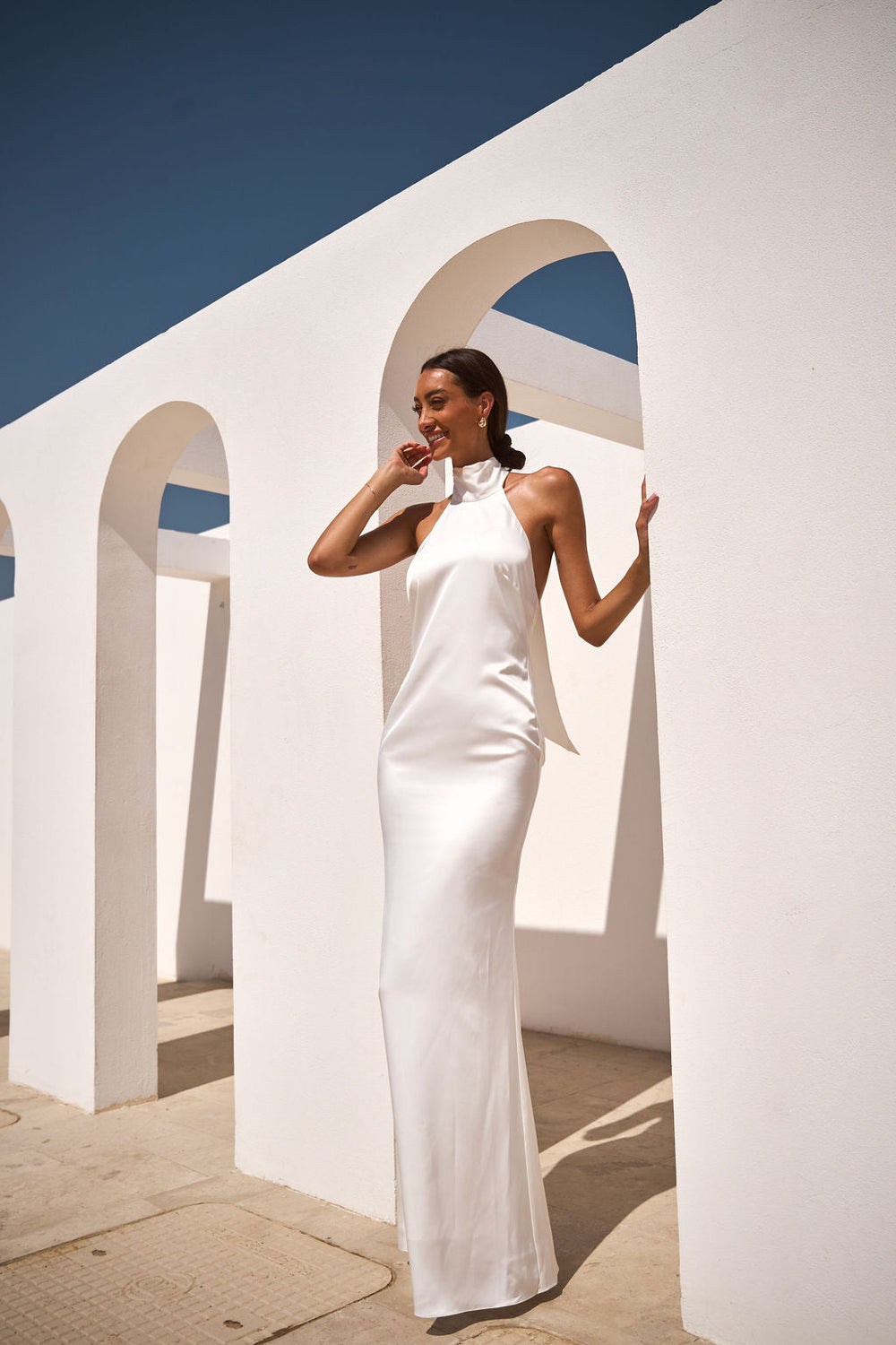 White Rosie dress by ALB London UK displayed on a hanger, with soft fabric and elegant design details visible.