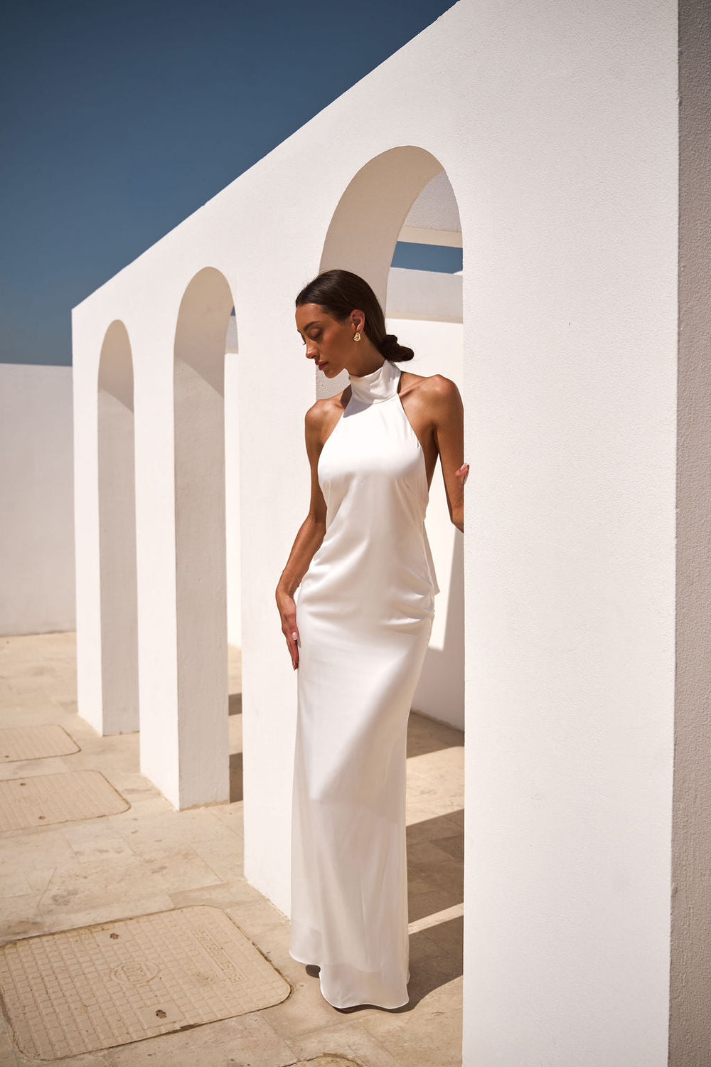 Elegant white Rosie dress by ALB LONDON UK displayed on a hanger, showcasing its classic design and soft fabric.