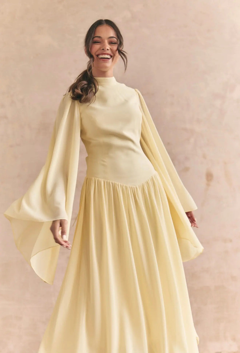 Limoncello dress by Anne Louise Boutique displayed on a hanger, featuring a flowy yellow fabric with delicate floral details.