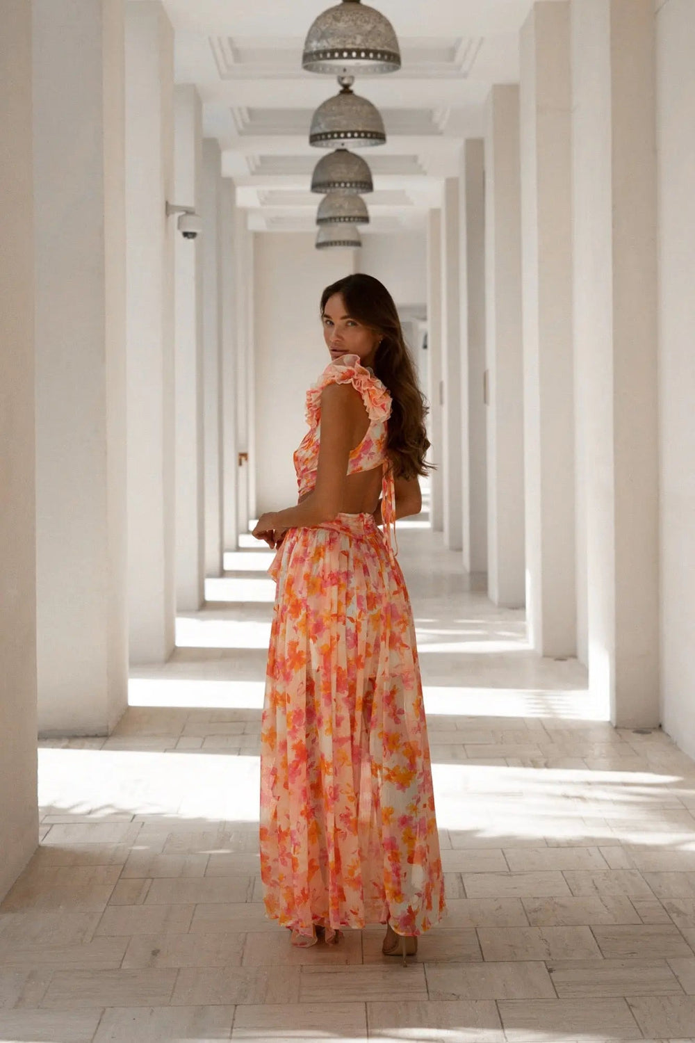 Orange and fuchsia floral Cassini maxi dress by Anne Louise Boutique, flowing fabric with a fitted bodice and vibrant pattern.